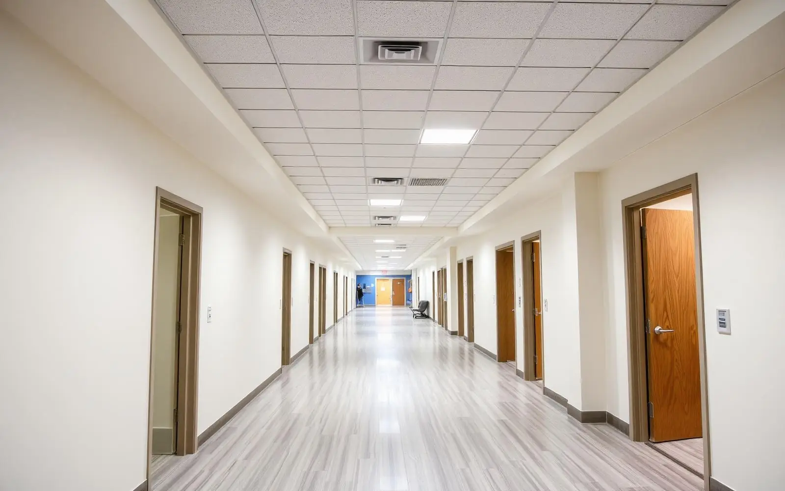 Completed community health center exam room corridor with new flooring and lighting in Arizona
